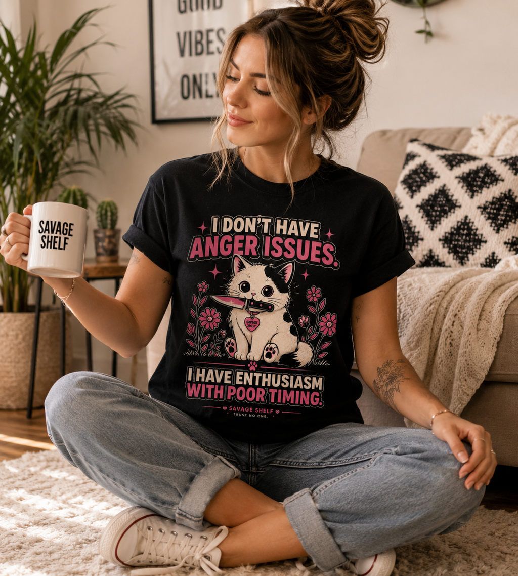 A woman sits cross-legged on a rug in a cozy living room setting, wearing a black graphic t-shirt with a dog design and text that reads 'I DON'T HAVE ANGER ISSUES. I HAVE ENTHUSIASM WITH POOR TIMING.